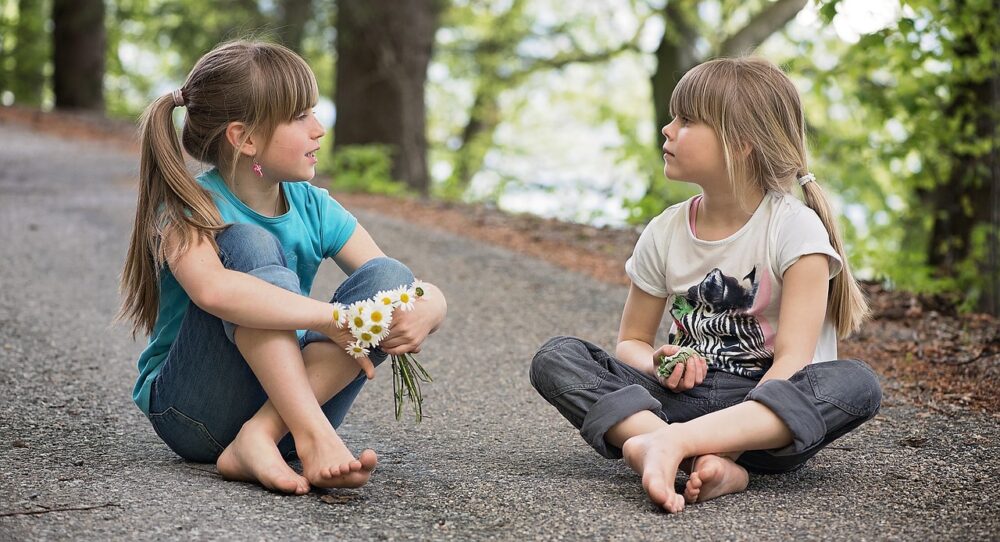 地べたに座って会話する子供