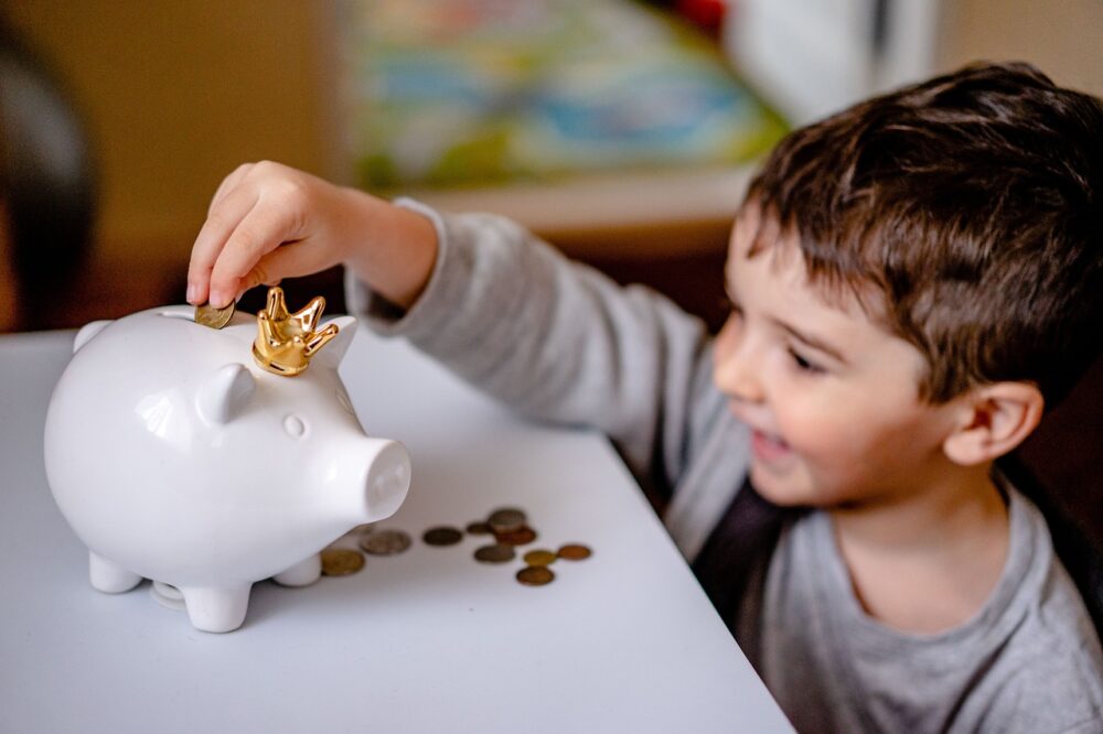 豚の貯金箱に貯金する子供